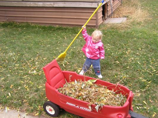 Sarah sweeps some leaves.
