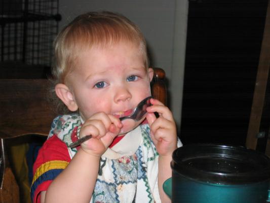 Noah licks the chocolate spoon.