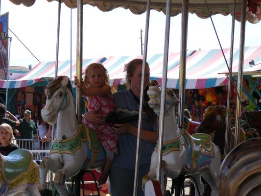 Sarah rides a carousel horse.