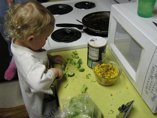 Noah chops up some brocolli.