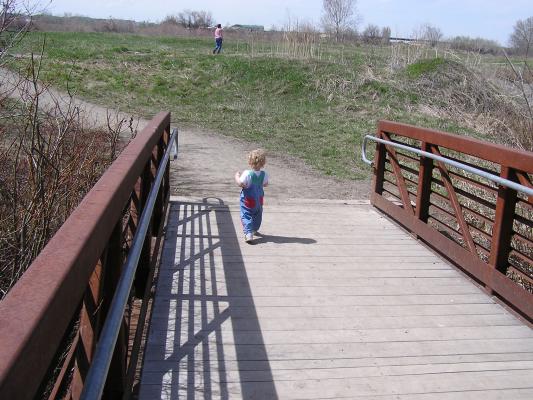 Noah walks down the trail from the bridge.