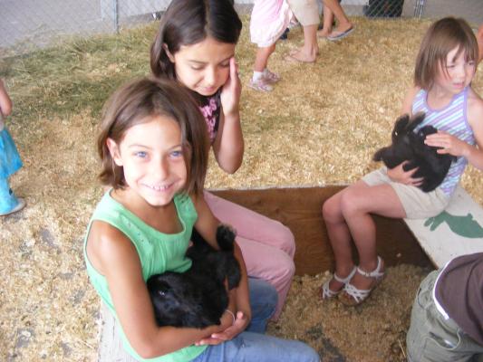 Andrea and Malia hold bunnies at the Fair.