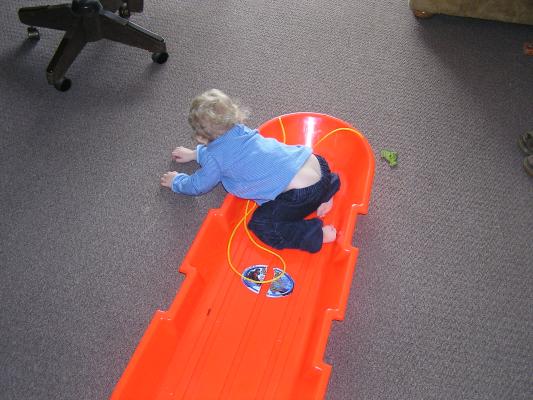 Noah plays with his sled.