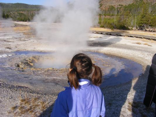 Andrea watches a steaming geyser.