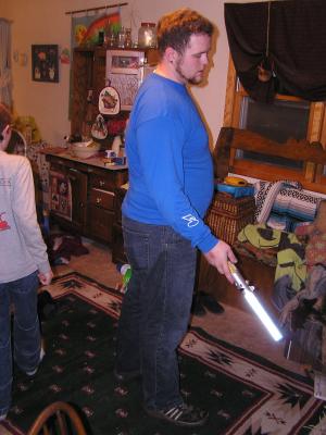 Titus plays a Star Wars game with a light saber.