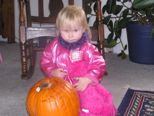 Sarah and her pink bear color a pumpkin.
