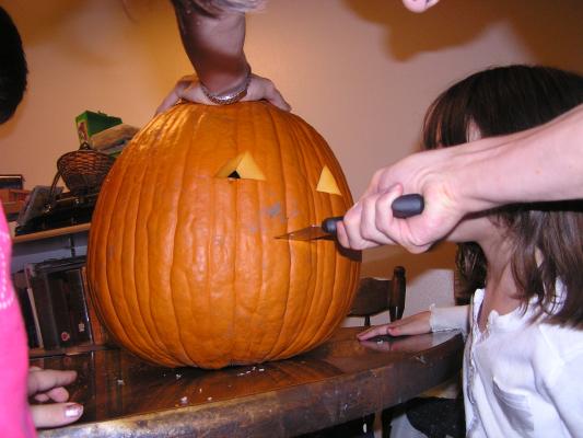 The pumpkin is starting to look more like a jack-o-lantern.