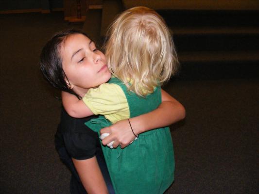 Sarah hugs malia after Malia\'s baptism.