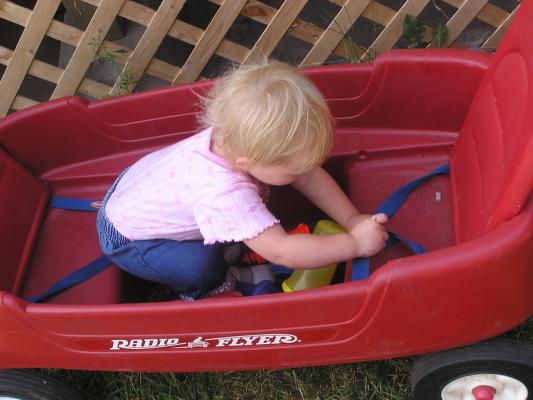Sarah plays with the buckles in the wagon.
