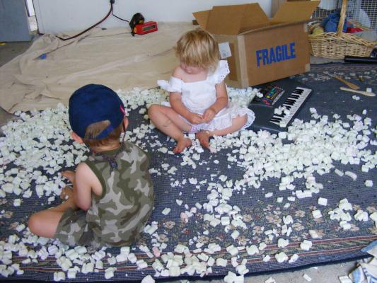 Noah and Sarah play with a box of styrofoam peanuts