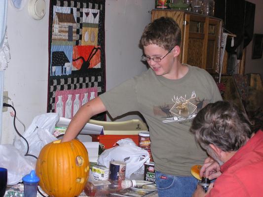 Joe puts his hand in the pumpkin.