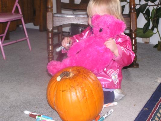 Sarah and her bear color a pumpkin