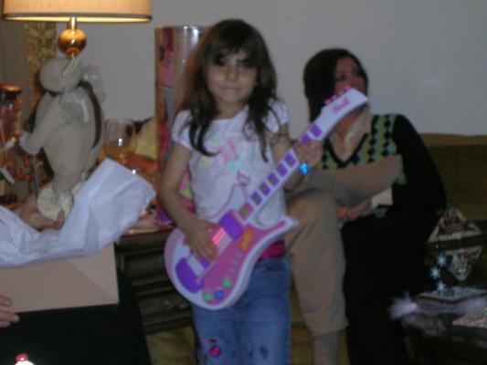 Andrea plays with a plastic guitar