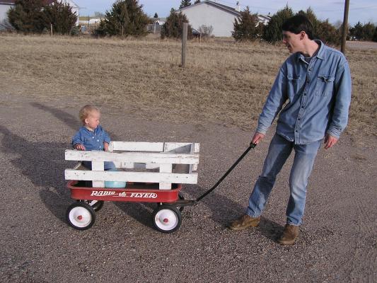 Daddy pulls Noah in a wagon.