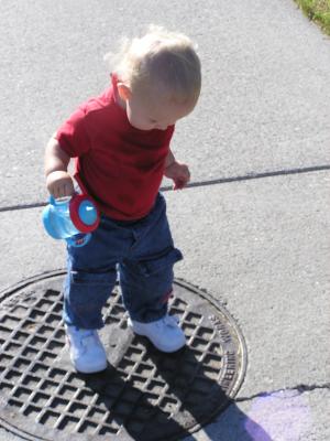 Using new shoes to stomp on a manhole cover.