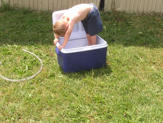 Noah plays in the water filled cooler.