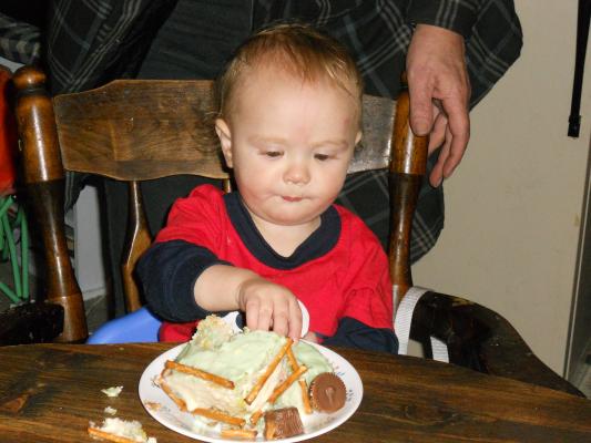 Joshua tries that first birthdya cake care. YUM.