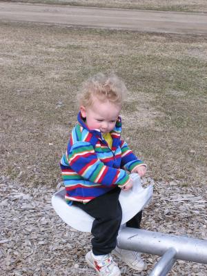 Noah sits on the teetertotter.