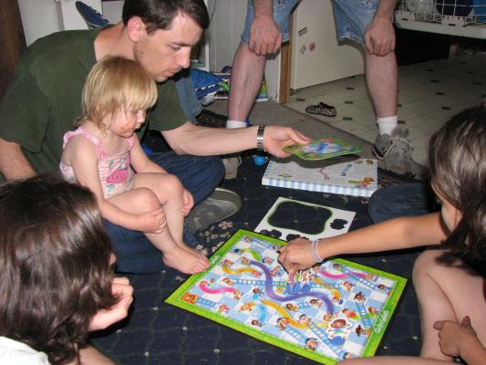 Mike, DAvid and SArah, and Malia play 
Shoots and Ladders.