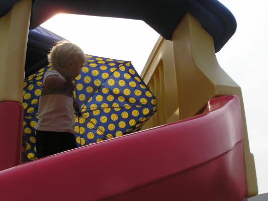 Noah plays with the umbrella at the playground.
