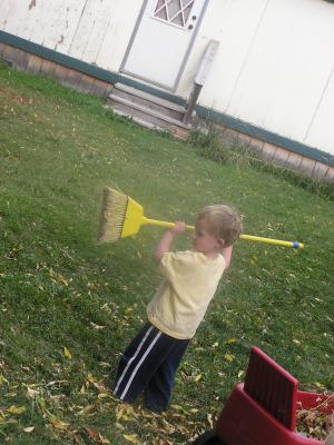 Noah sweeps up some leaves.