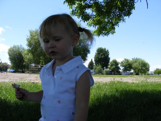 Sarah eats a radish at the park.