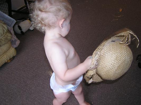 Noah plays with an old straw hat.