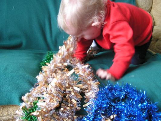 Pushing tinsel off the couch.