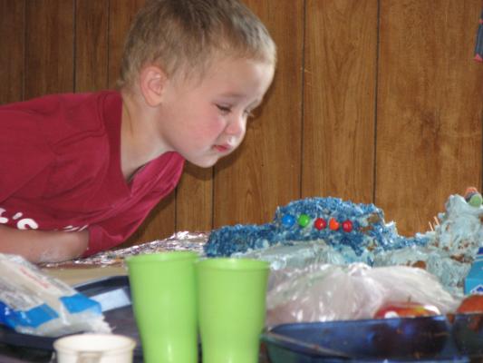 Noah puts some candy on his cake.