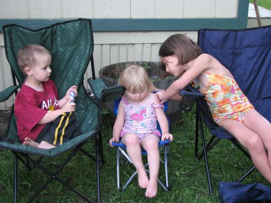 Noah, Sarah, and Andrea relax in lawn chairs.