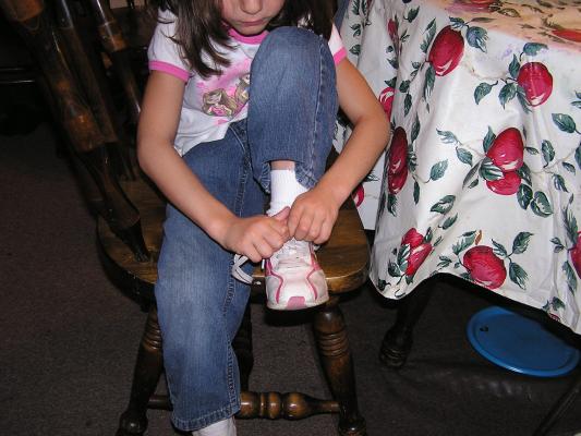 Andrea ties her shoe with two rabbit ears.