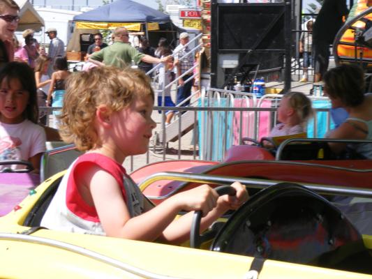 Noah drives a car at the Carnival at the fair.