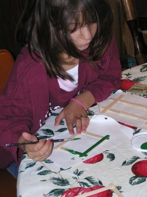 Andrea paints popsickle stick picture frames.