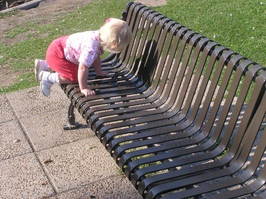 Sarah plays on a park bench.