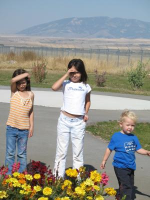Andrea, Malia and Noah by some yellow flowers.