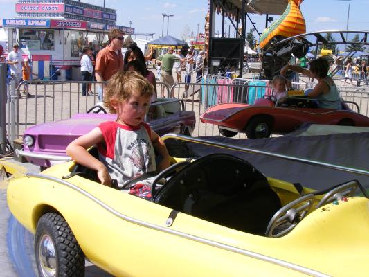 Noah rides a car at the fair.