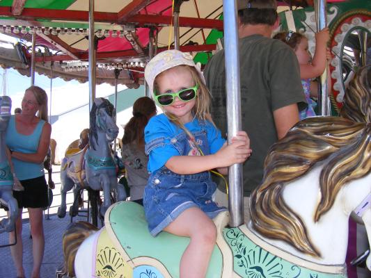 Sarah rides the Carosel at the fair.