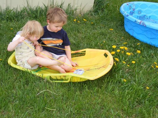 Sarah and Noah play in the sled in summer