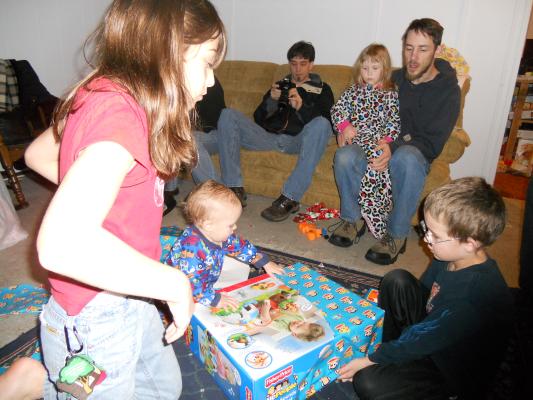 the family gathers around Joshua for gift opening. 