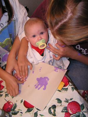 Sarah makes purple hand prints.
