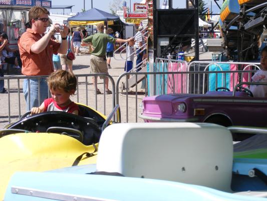 Noah drives a car at the fair.