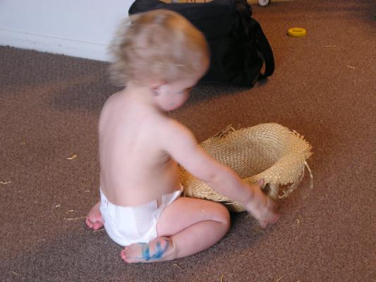 Noah plays with an old straw hat.