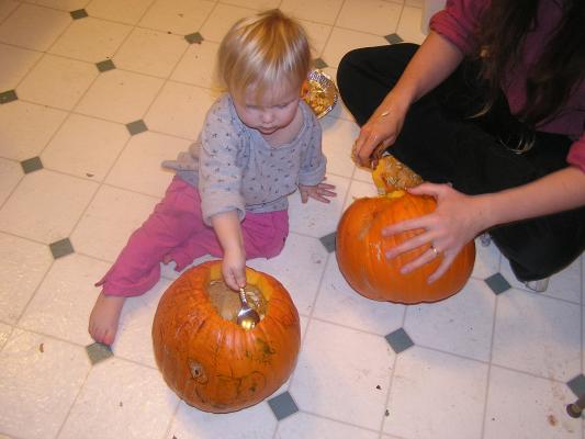 Sarah scoops out a pumpkin.