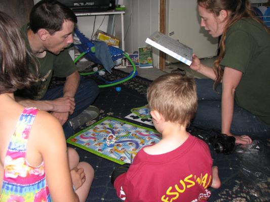 Malia, David, Katie and Noah play a board game.