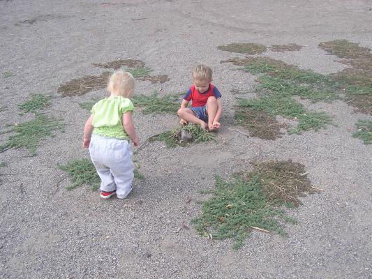 Sarah and noah playing in the sand at the park .