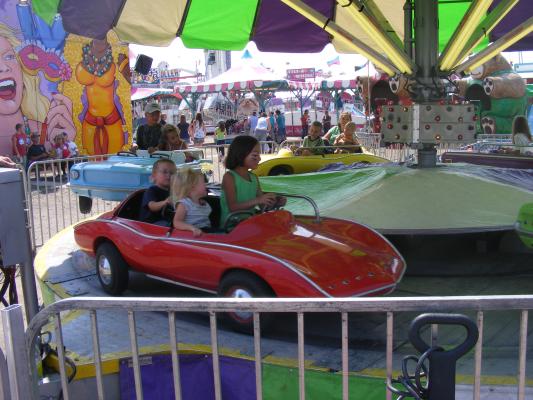 Andrea, Sarah and Noah ride a car at the fair.