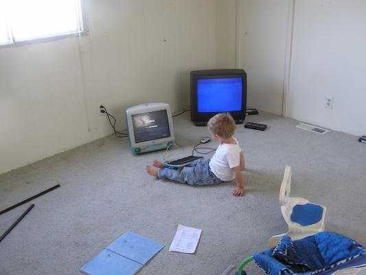 Noah with a computer and TV in our new trailer home