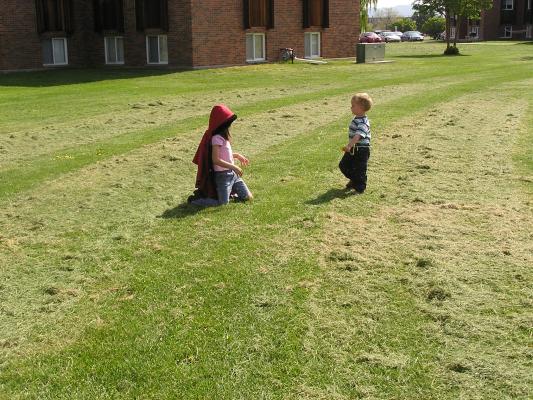 Andrea and Noah play in the grass clippings.