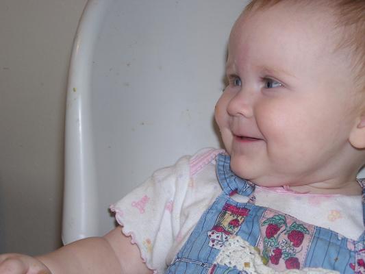 Sarah is happy in her high chair.