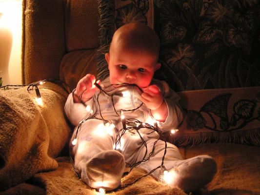 Noah plays with Christmas lights.
